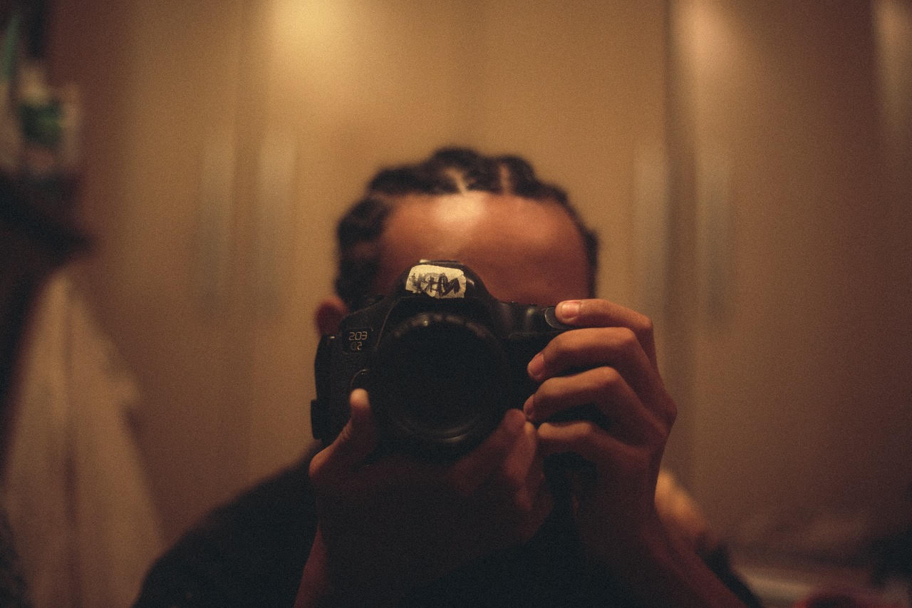 Close up of a camera being held by a masc presenting photographer