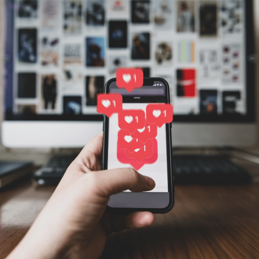Celll phone with hearts and likes popping off the screen