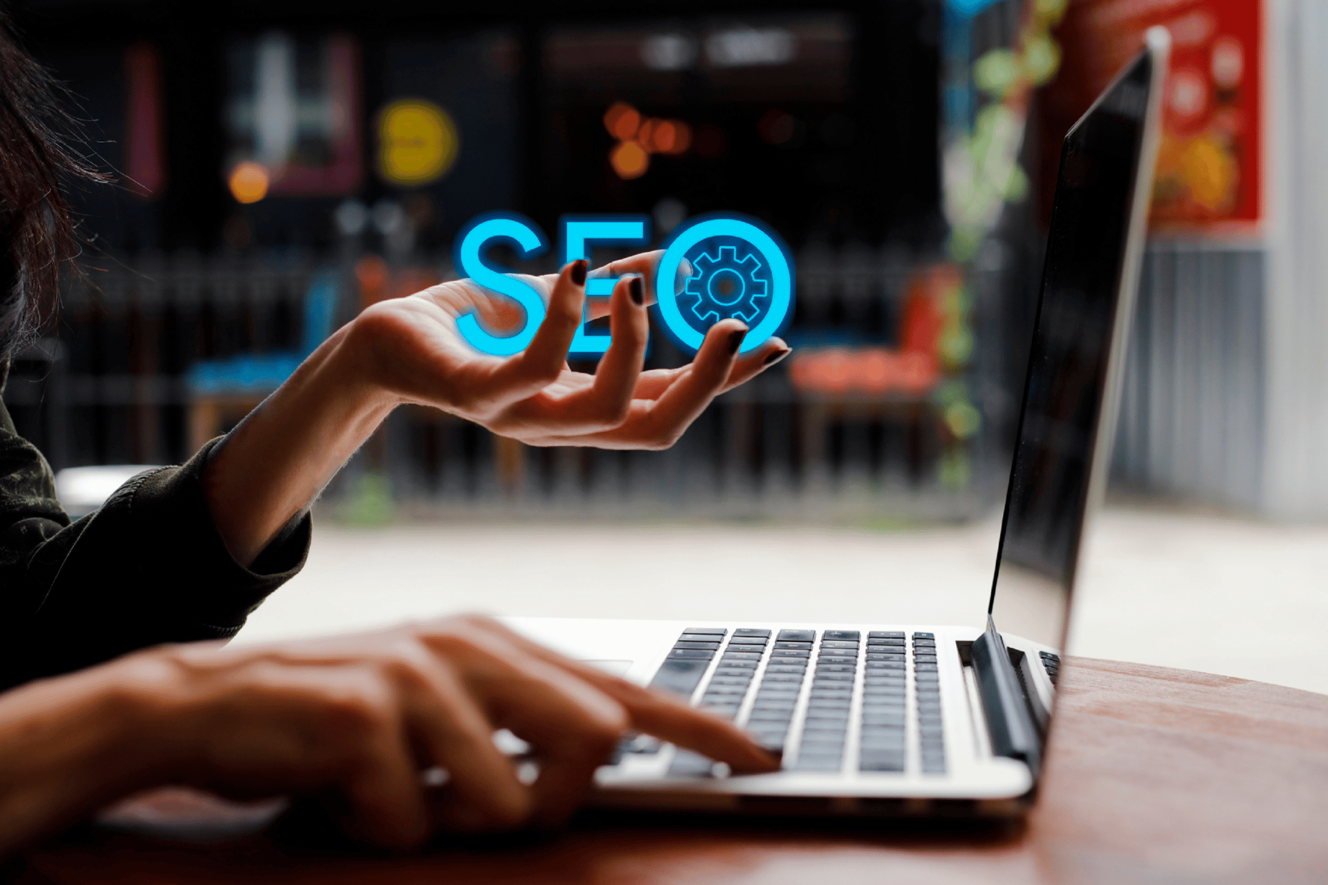 seo-image-holding-blue-seo-letters-in-hand-clicking-on-laptop-in-office-setting