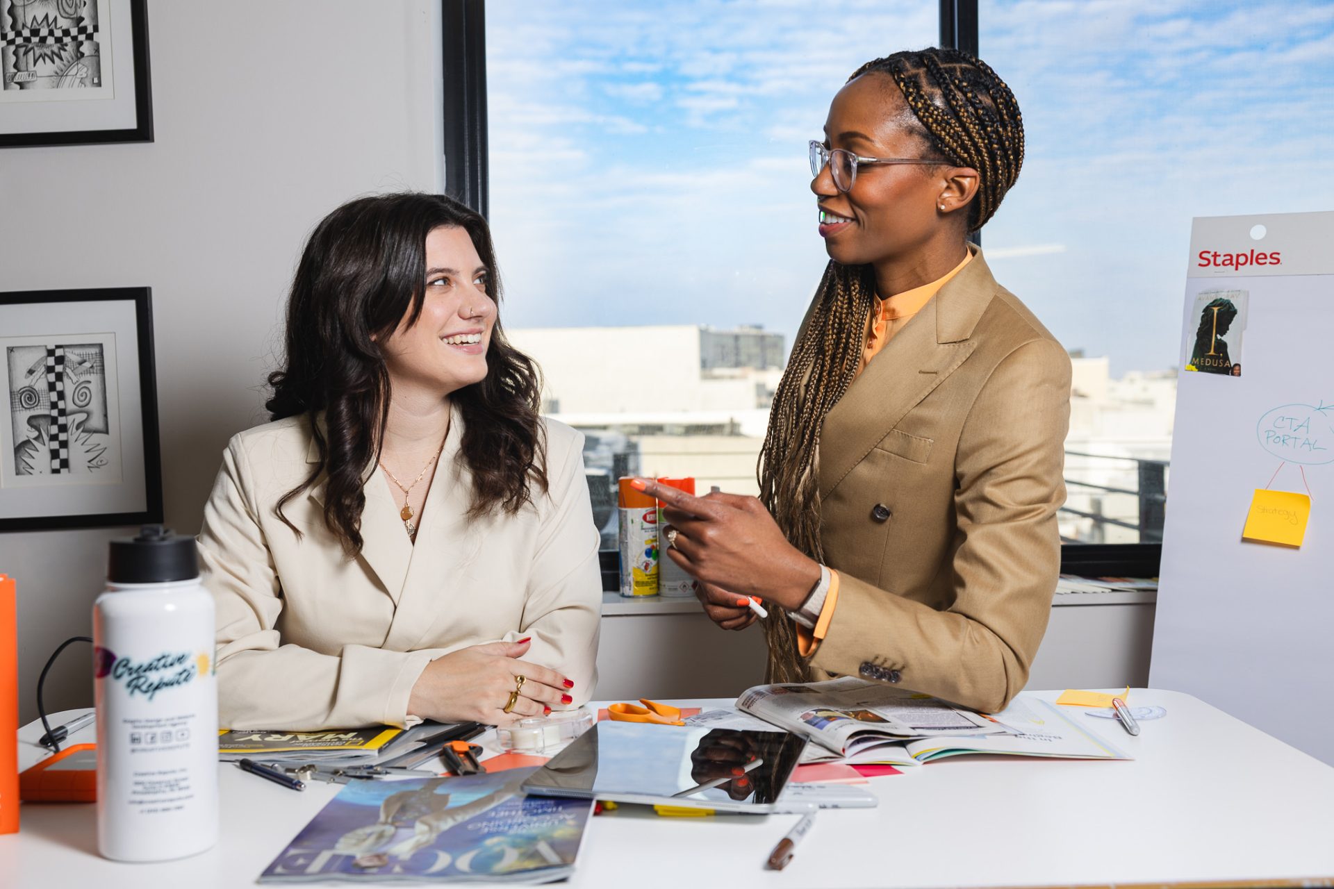 Photo of graphic designer Tara and CEO Nile working together in workspace