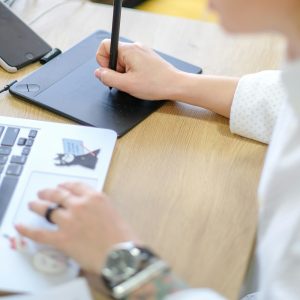 image of graphic designer working on laptop and digital drawing pad